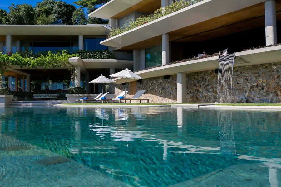 Pool with cascading water feature and sun loungers