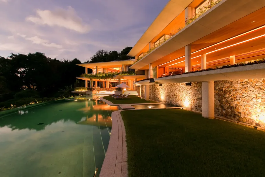 Villa and lawn lit beside the pool in the evening